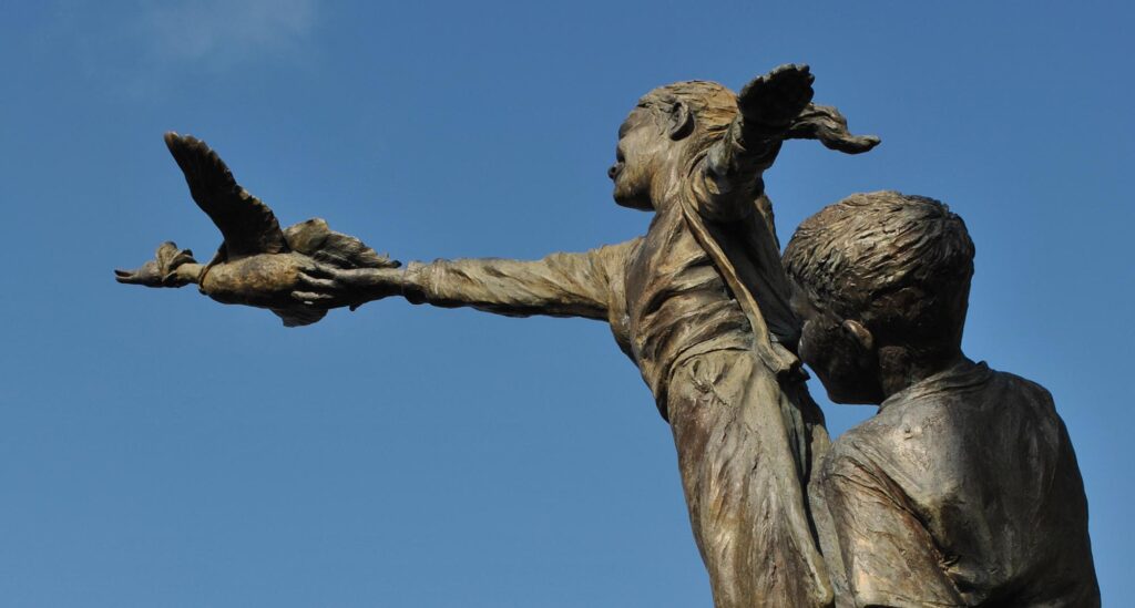 Image of the statue at the World of Beatrix Potter attraction in Bowness on Windermere. The statue depicts three children releasing Potter's character Jemima Puddle-Duck